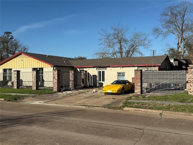 view of front of property featuring a fenced front yard, a gate, brick siding, and board and batten siding