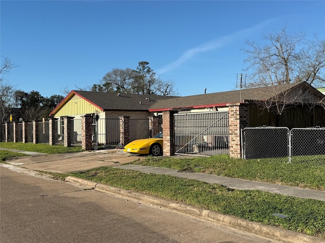 view of front of house with a fenced front yard, brick siding, driveway, and an attached garage