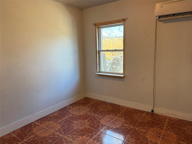 empty room with dark tile patterned flooring, baseboards, and a wall mounted AC