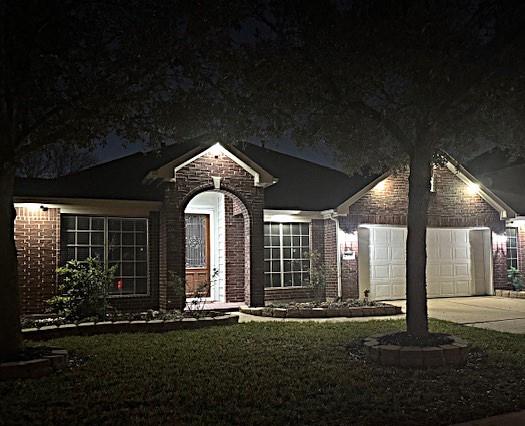 single story home with brick siding, a lawn, driveway, and an attached garage