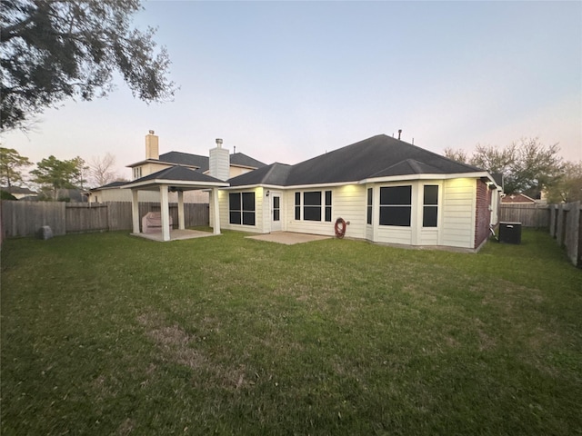 back of house featuring a patio, a fenced backyard, central AC, a gazebo, and a lawn