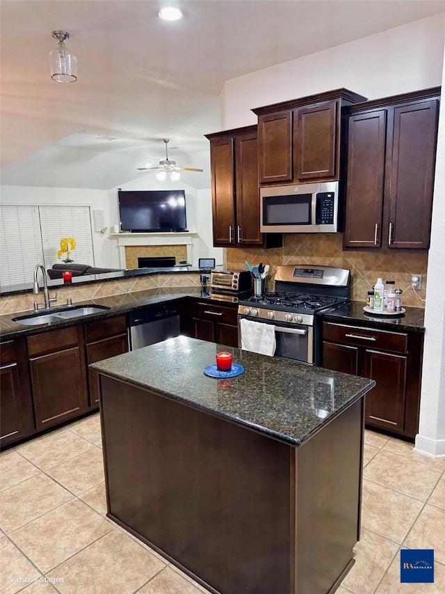 kitchen with a sink, stainless steel appliances, ceiling fan, and light tile patterned floors