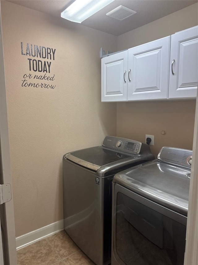 laundry area featuring light tile patterned floors, cabinet space, visible vents, and washing machine and clothes dryer