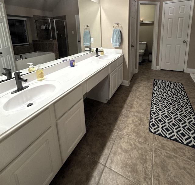 bathroom featuring a sink, toilet, double vanity, and a shower stall