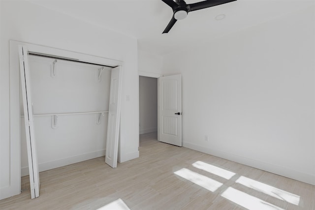 unfurnished bedroom featuring a ceiling fan, a closet, baseboards, and wood finished floors