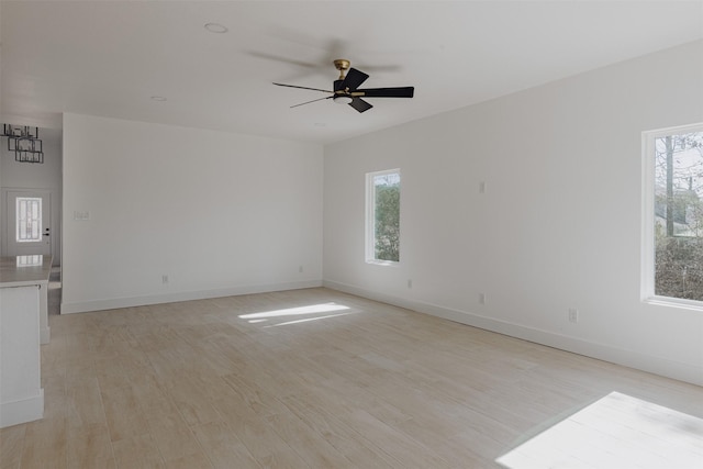 empty room with light wood finished floors, ceiling fan, and baseboards