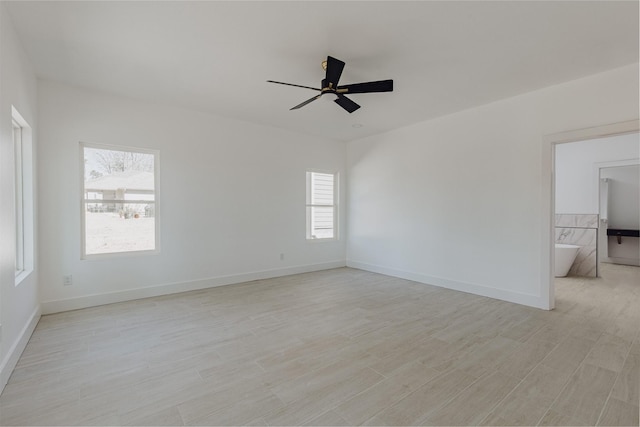 spare room with light wood-style floors, ceiling fan, and baseboards