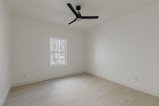 empty room with a ceiling fan, light wood-style flooring, and baseboards