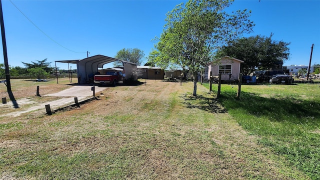 view of yard featuring a detached carport and driveway