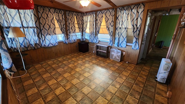 empty room featuring wood walls and a ceiling fan