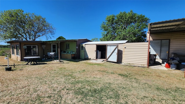 rear view of property featuring an outbuilding, a yard, a patio, and a shed