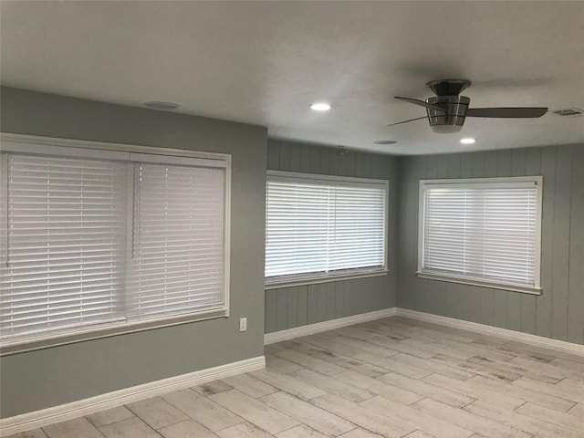 spare room with visible vents, ceiling fan, baseboards, and wood finished floors