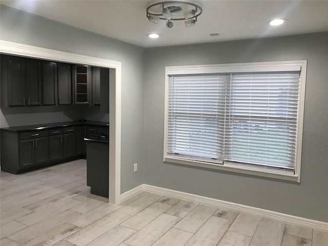 unfurnished dining area featuring light wood finished floors, recessed lighting, and baseboards