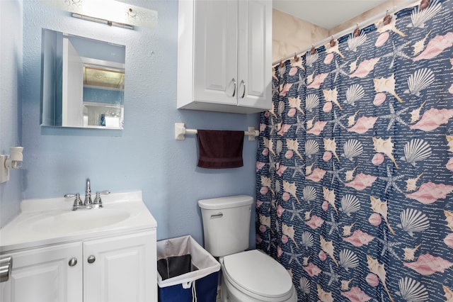 bathroom featuring curtained shower, vanity, and toilet