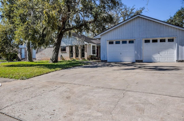 view of front facade featuring an attached garage, brick siding, driveway, and a front lawn