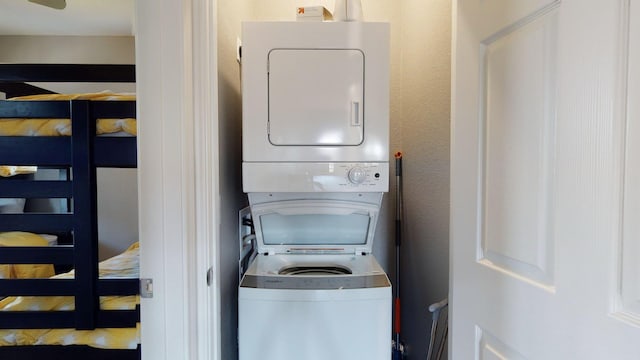 clothes washing area with laundry area and stacked washer and clothes dryer