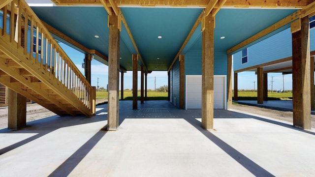 view of patio / terrace featuring stairs and a detached garage