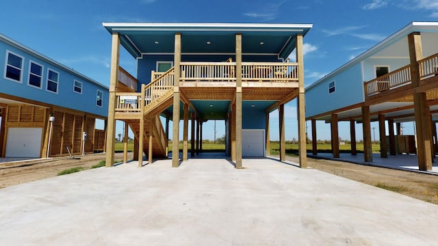 back of house featuring stairs, a carport, and an attached garage