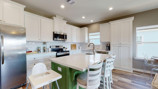 kitchen featuring visible vents, stainless steel appliances, a sink, and white cabinetry