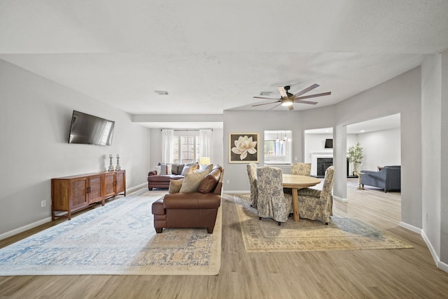 dining room featuring visible vents, a fireplace, baseboards, and wood finished floors