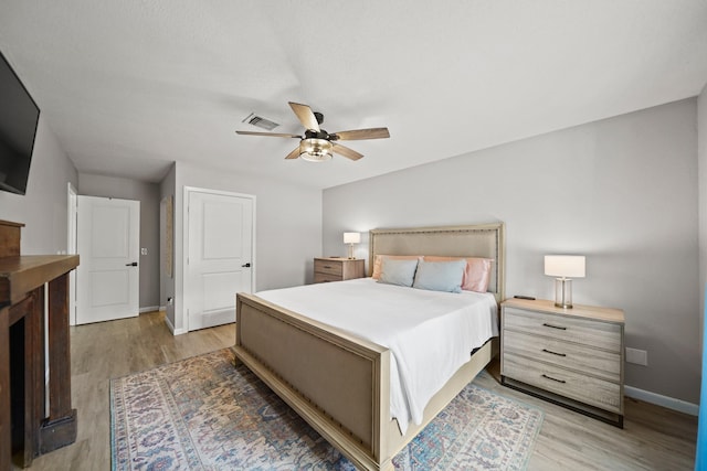 bedroom with visible vents, a ceiling fan, light wood-style flooring, and baseboards