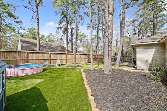 view of yard with fence and a fenced in pool