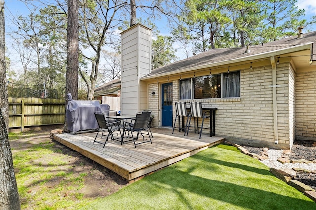 deck with a yard, fence, and grilling area