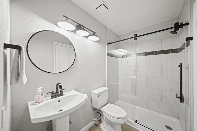 full bath with visible vents, toilet, wood finished floors, a shower stall, and a sink