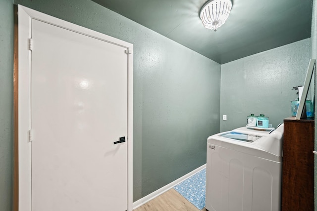 laundry room with washer / dryer, baseboards, laundry area, and light wood finished floors