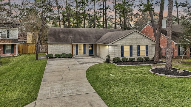 ranch-style home featuring an attached garage, fence, concrete driveway, and brick siding