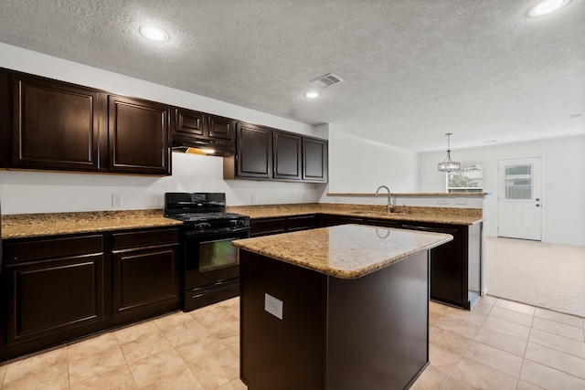 kitchen with visible vents, a peninsula, black gas stove, under cabinet range hood, and a sink