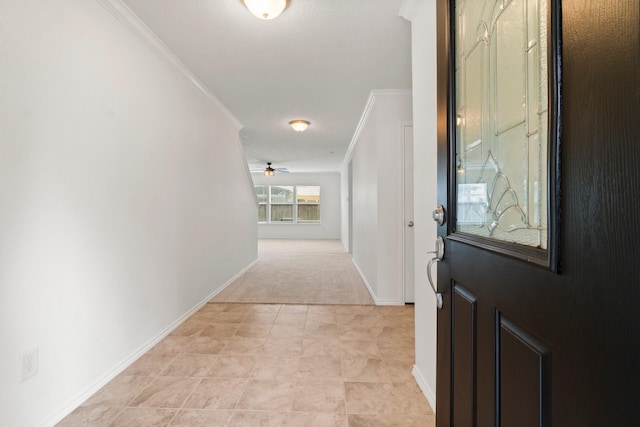 entryway with baseboards, a ceiling fan, and crown molding