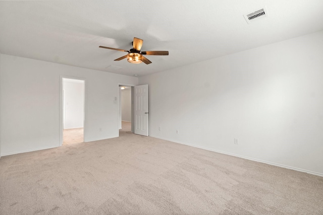 unfurnished room featuring light colored carpet, visible vents, ceiling fan, and baseboards