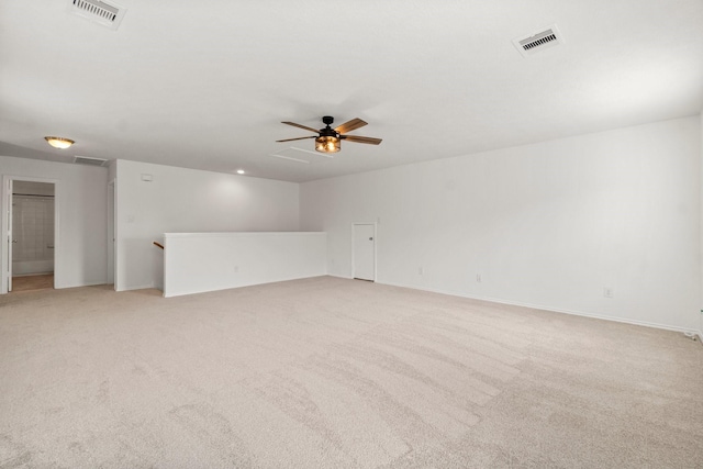 spare room featuring visible vents, a ceiling fan, and light colored carpet