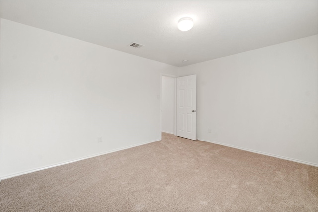 unfurnished room featuring baseboards, visible vents, and light colored carpet