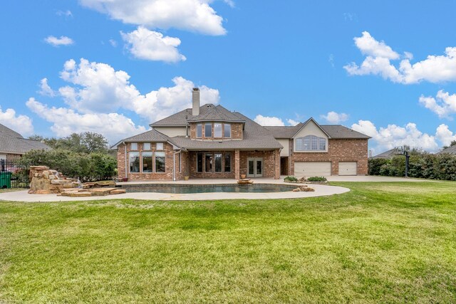 20803 Fairhaven Crossing Dr, Cypress, TX 77433 - rear view of house with brick siding, a garage, a chimney, and a lawn