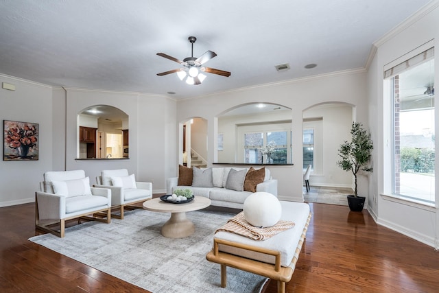 living room with ornamental molding, wood finished floors, visible vents, and baseboards