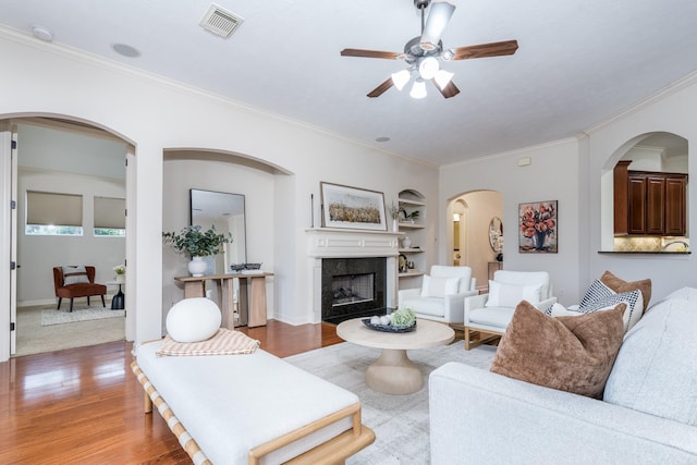 20803 Fairhaven Crossing Dr, Cypress, TX 77433 - living area featuring ornamental molding, wood finished floors, ceiling fan, a high end fireplace, and built in shelves