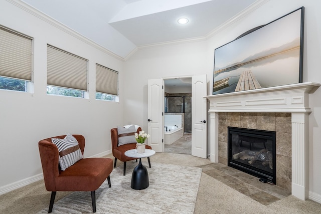 living area featuring baseboards, carpet floors, a tile fireplace, and crown molding