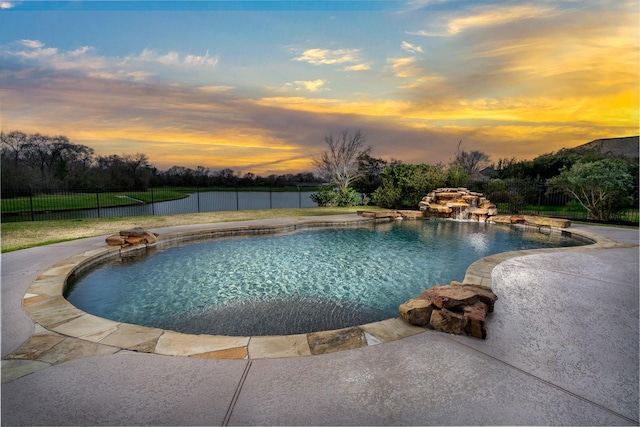 pool at dusk featuring a patio area, fence, and a fenced in pool