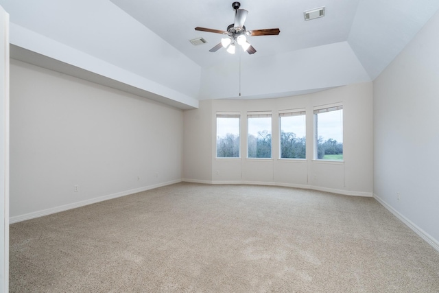 spare room featuring a ceiling fan, lofted ceiling, visible vents, and light colored carpet