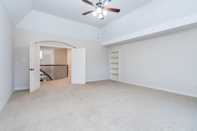 unfurnished room with light carpet, baseboards, built in features, a ceiling fan, and lofted ceiling