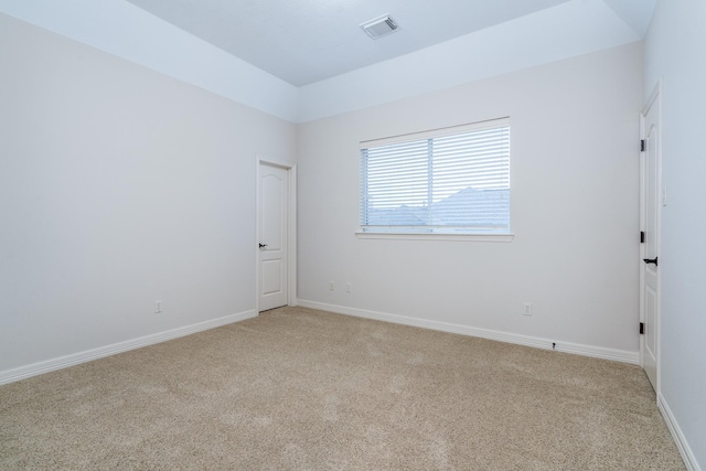 empty room featuring light colored carpet, visible vents, and baseboards