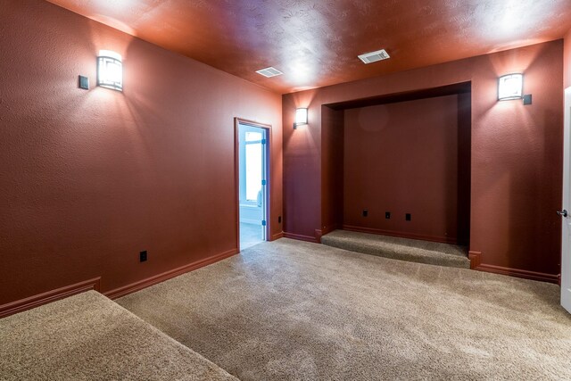 spare room featuring carpet flooring, visible vents, and baseboards