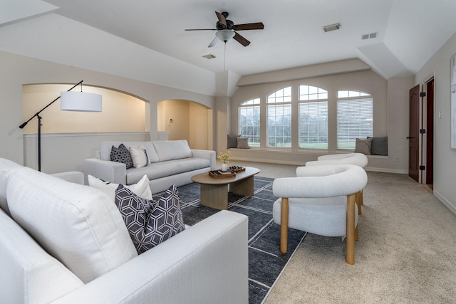 living room featuring arched walkways, carpet flooring, and visible vents