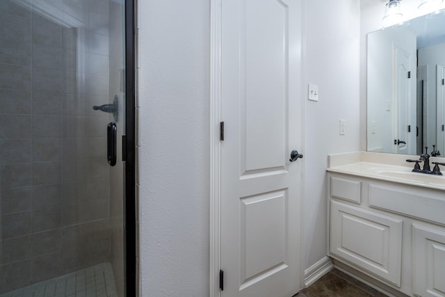 bathroom featuring a shower stall and vanity