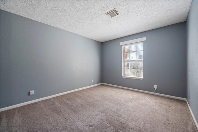 unfurnished room with carpet, a textured ceiling, visible vents, and baseboards