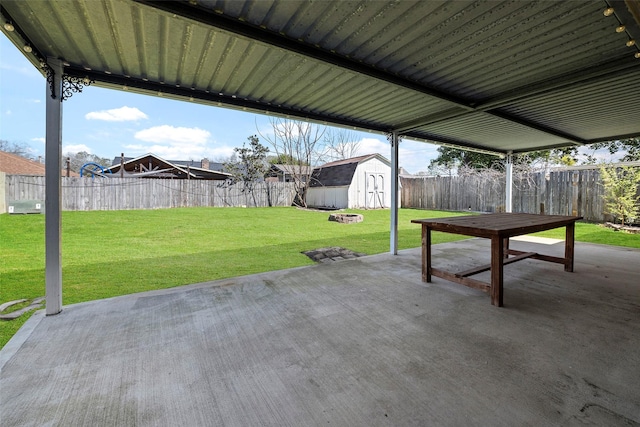 view of patio with a storage shed, a fenced backyard, and an outdoor structure