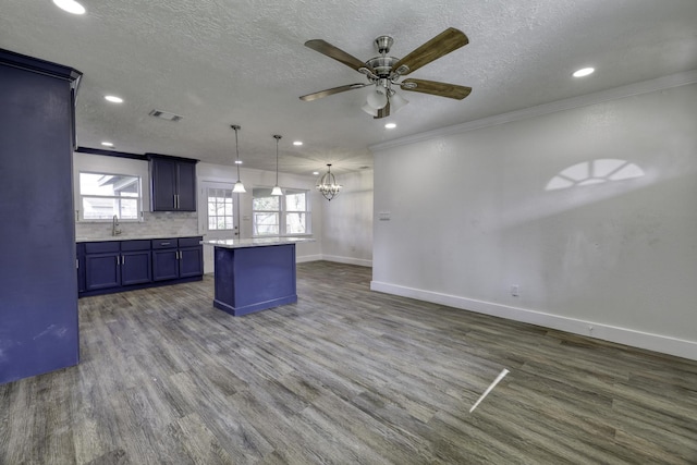 kitchen with visible vents, dark wood finished floors, blue cabinetry, ornamental molding, and a sink