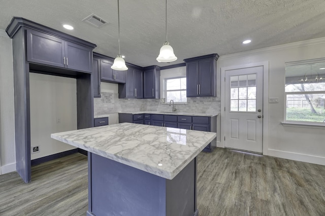 kitchen with a sink, visible vents, tasteful backsplash, and dark wood finished floors